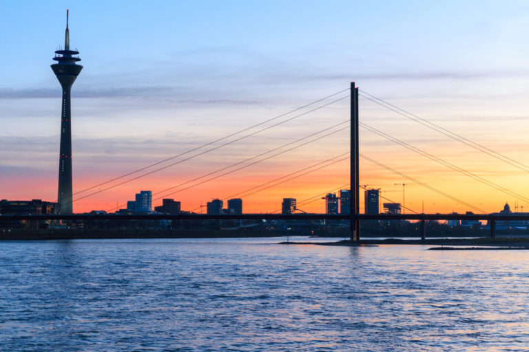 Panorama Düsseldorf mit dem Rheinturm und Brücke bei Sonnenuntergang