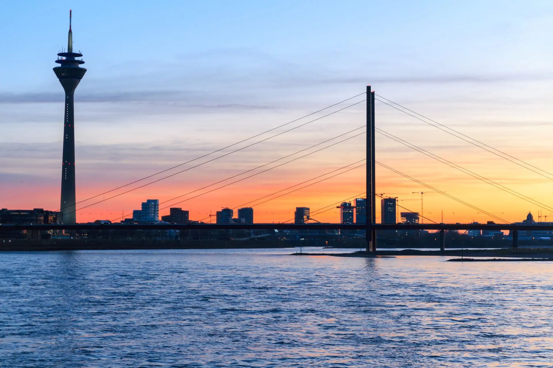 Panorama Düsseldorf mit dem Rheinturm und Brücke bei Sonnenuntergang