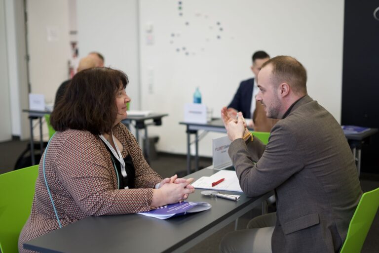 Zwei Menschen in einem Gespräch an einem Tisch